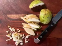 Gestückelte Quitte auf Holzbrett mit Messer – Vorbereitung zur Verarbeitung aus dem Garten auf Pellworm