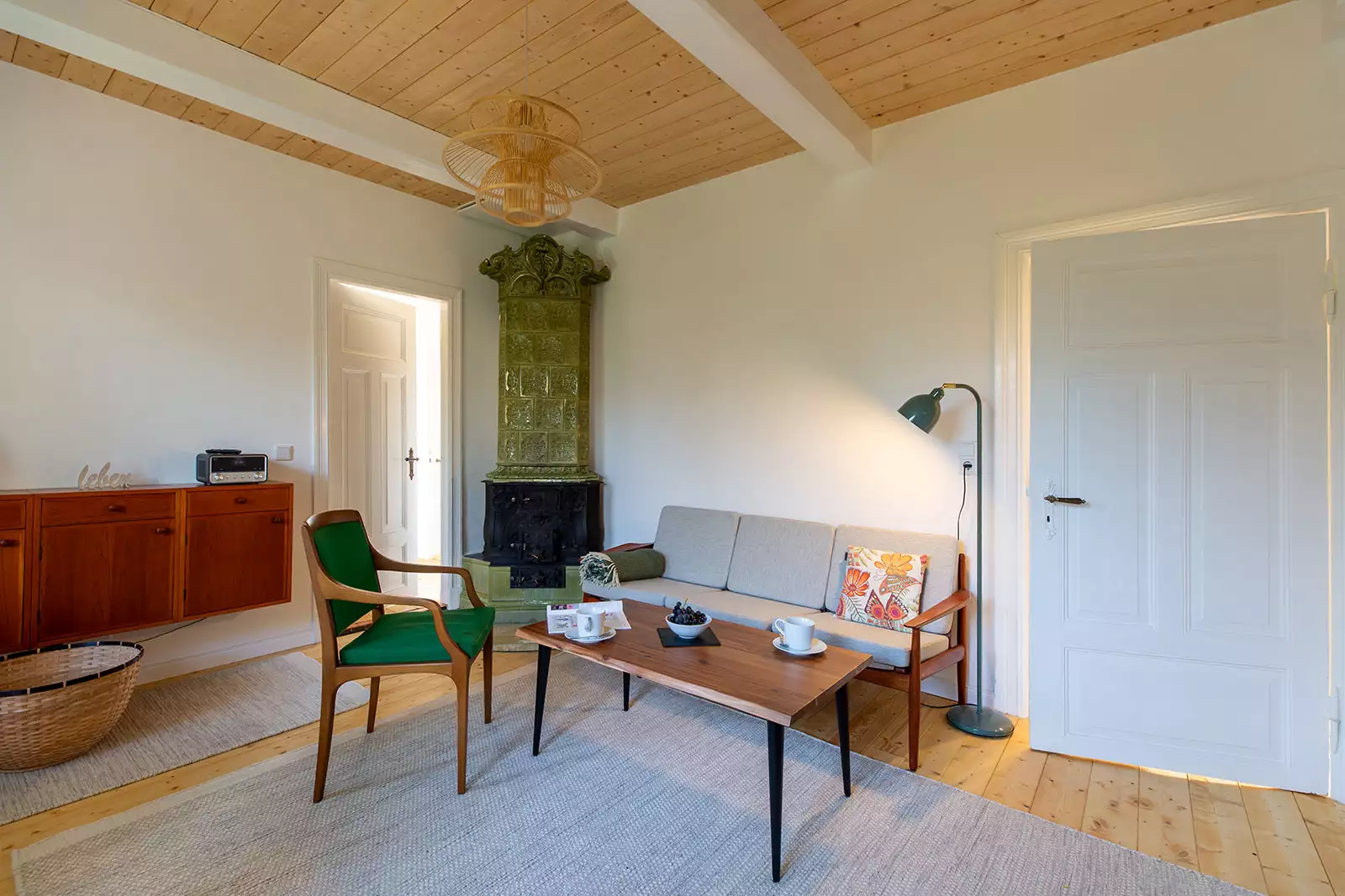 Wohnzimmer im Ferienhaus Deichschlösschen mit Couch, Tisch und Kachelofen