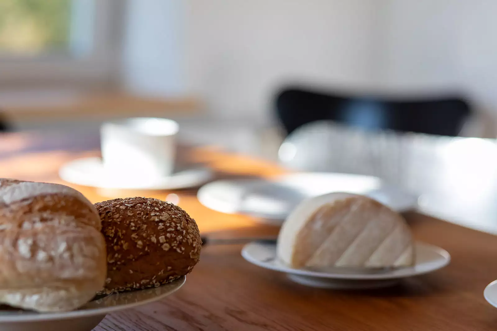 Frühstücksdetail im Ferienhaus Deichschlösschen mit Brötchen, Käse und Geschirr