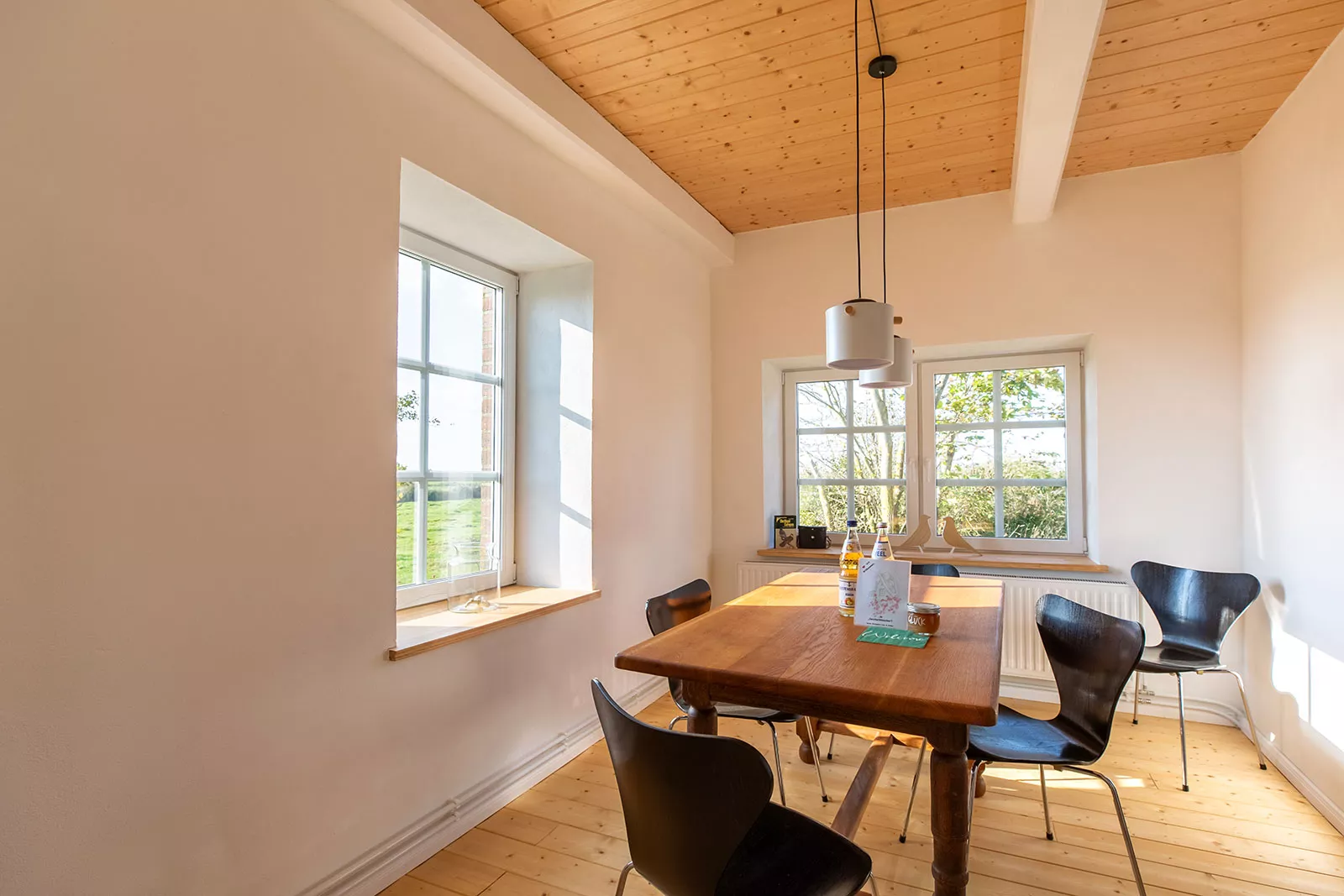 Esszimmer im Ferienhaus Deichschlösschen mit Tisch, Stühlen und Sonneneinstrahlung