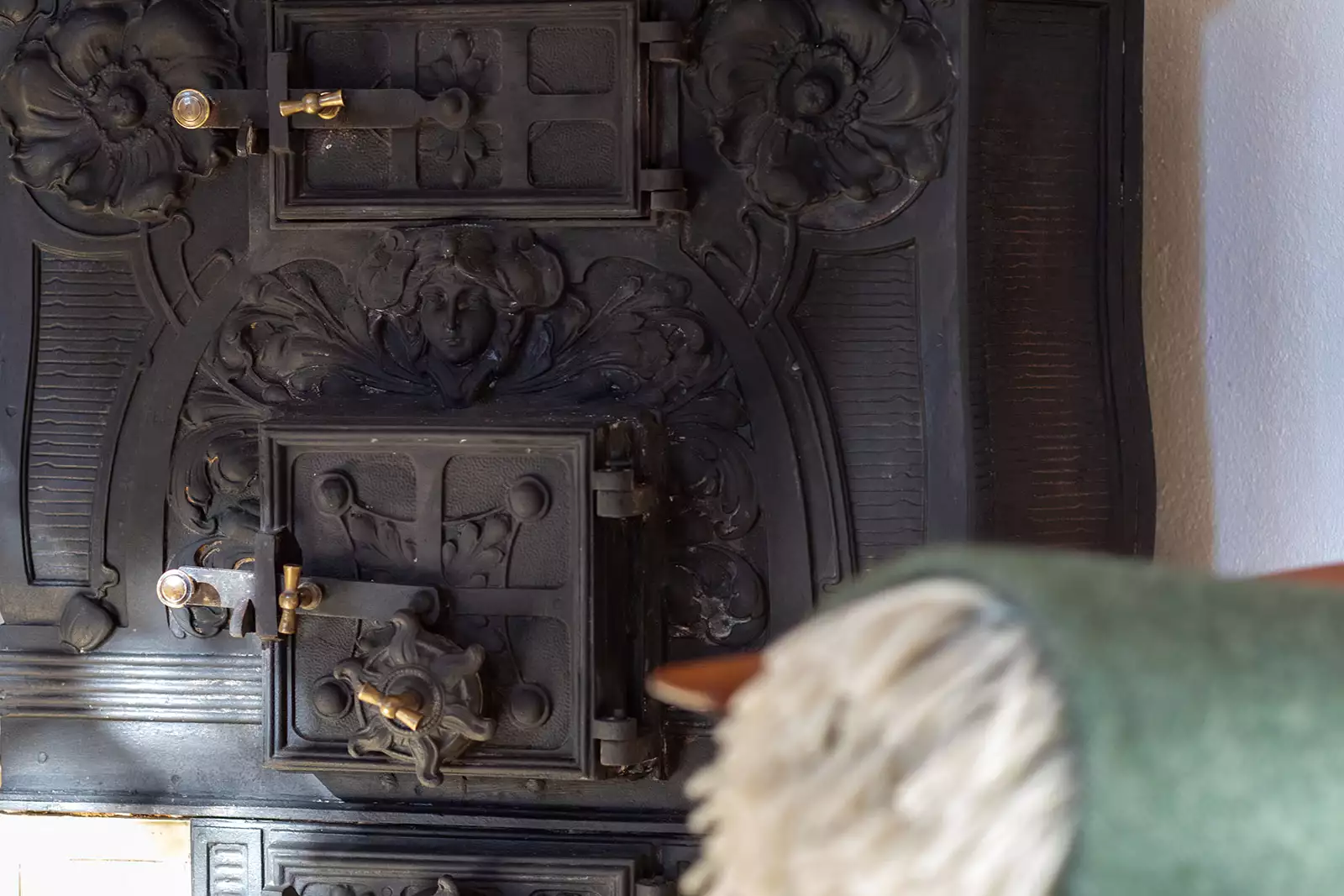 Detailaufnahme Kachelofen und Kuscheldecke im Ferienhaus Deichschlösschen