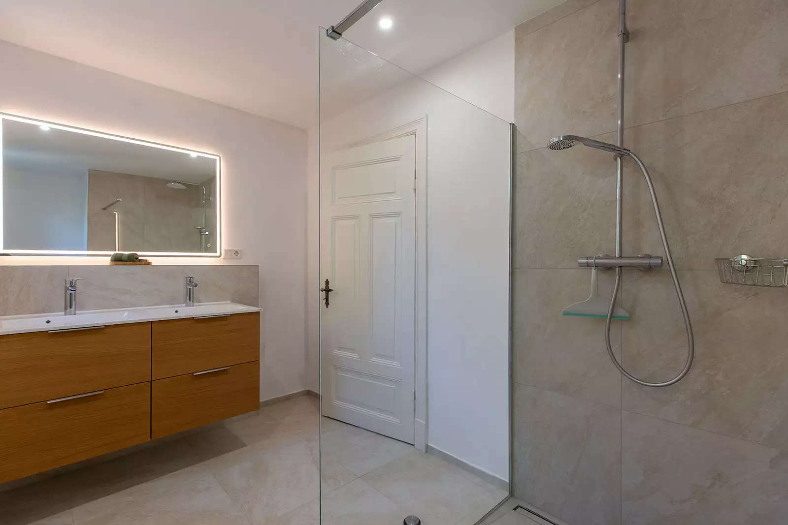 Badezimmer im Ferienhaus Deichschlösschen mit Dusche, Waschbecken und Spiegel