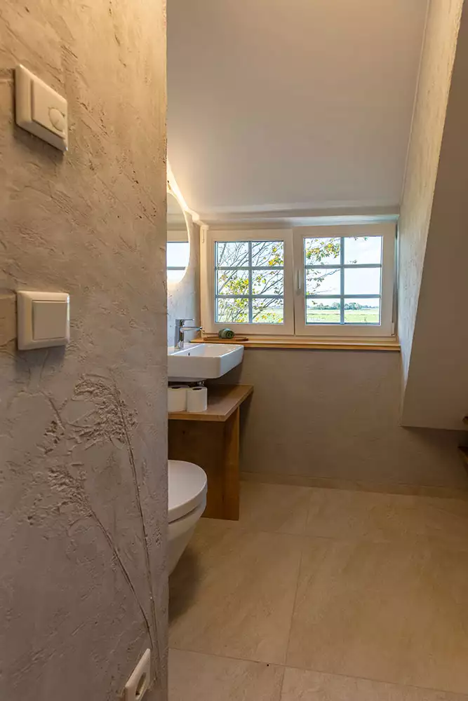 Badezimmer im Dachgeschoss des Deichschlösschens mit Waschbecken und Badewanne