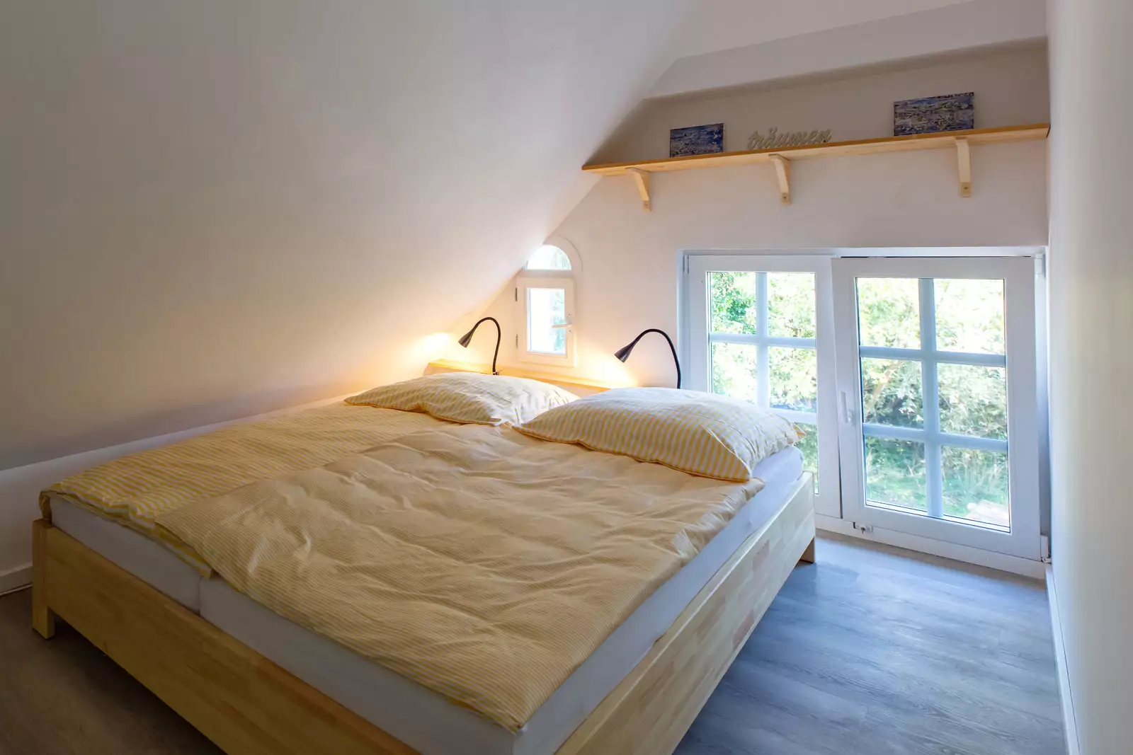 Schlafzimmer Ostseite im Deichschlösschen mit Doppelbett und Holzfußboden