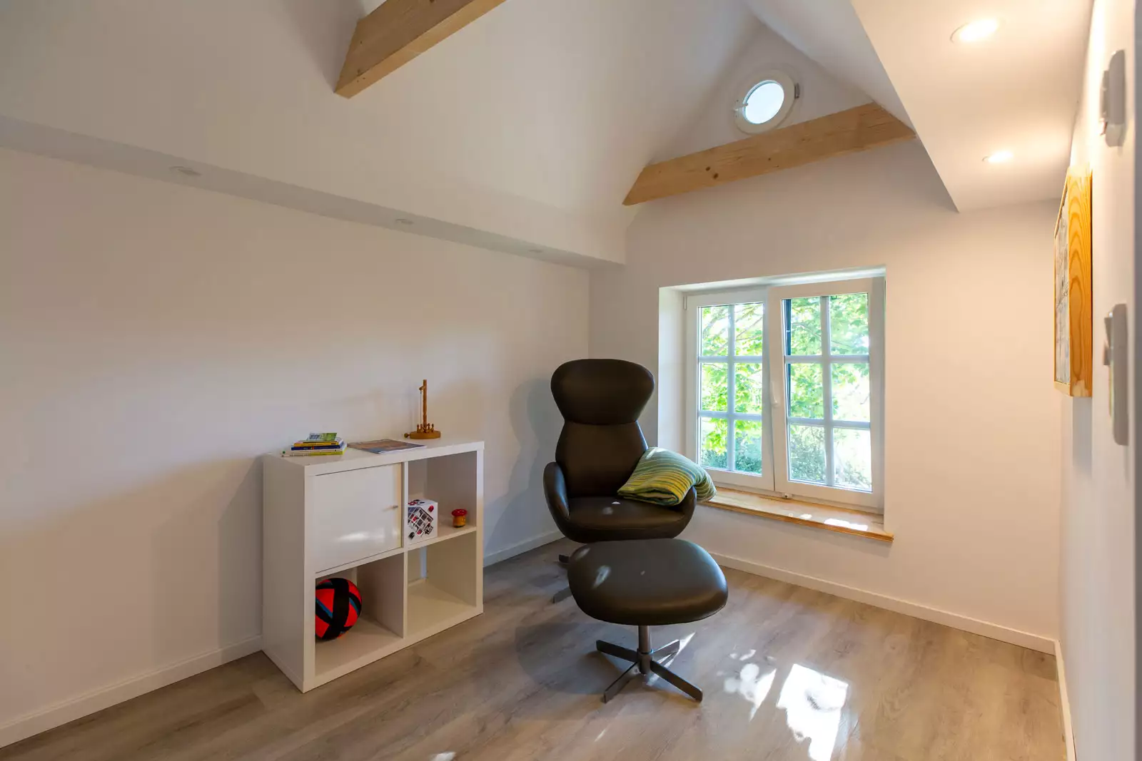 Lese- und Spielecke im Deichschlösschen mit Sessel, Sideboard und Spielzeug